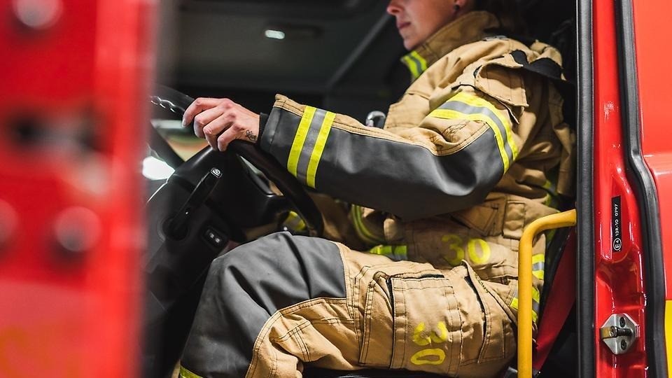 Personal från räddningstjänsten sitter i en brandbil