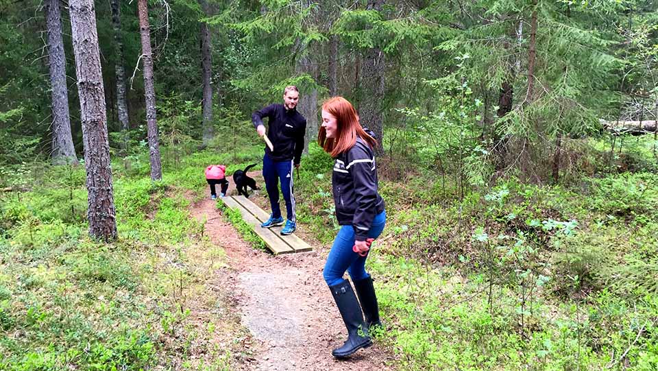 Här är tre unga och glada vandrare med hund på väg genom den fina tall- och granskogen på Duse Udde. 