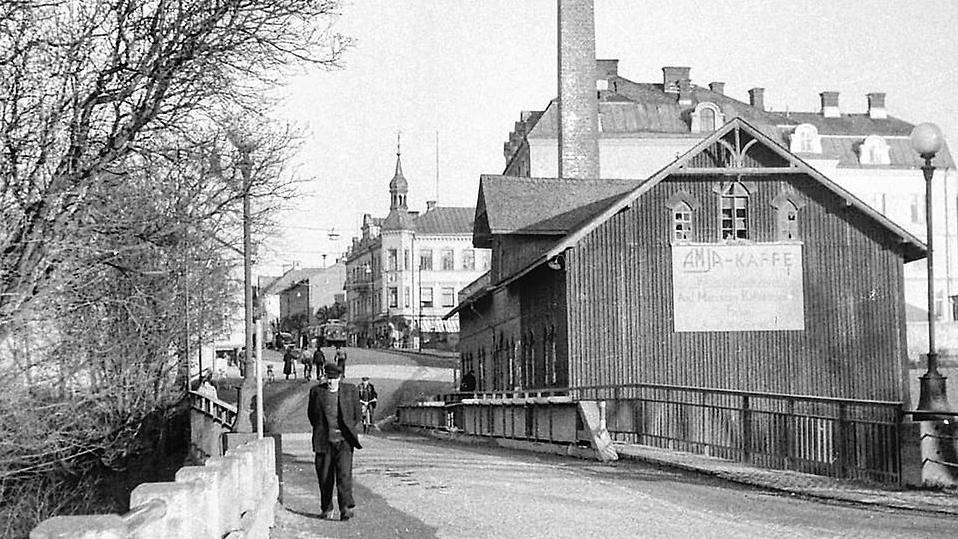 Svartvitt fotografi som visar en äldre man som promenerar över Strömbron i centrala Säffle under 1900-talets första hälft